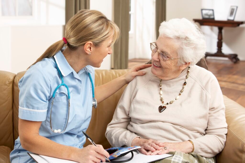 senior woman in discussion with health visitor at home